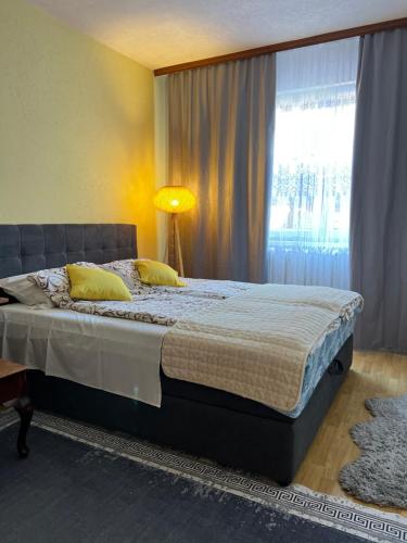 a bedroom with a bed with a lamp and a window at Guest House Bosnian House in Sarajevo