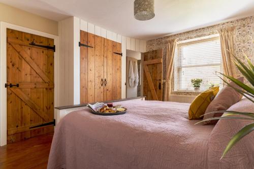 ein Schlafzimmer mit einem Bett mit einer Obstschale darauf in der Unterkunft The Cottage - Characterful, coastal family home with new hot tub in Dawlish