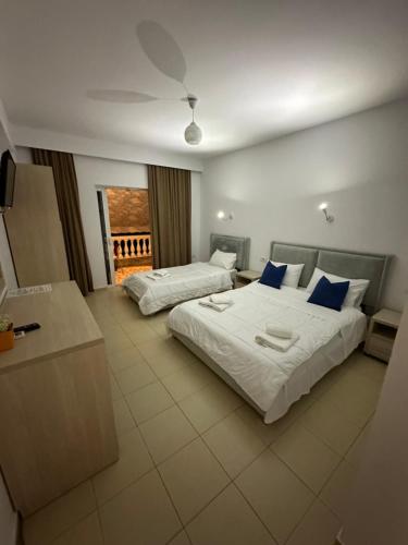 ケパロにあるVilla Gjikaのベッド2台とテレビが備わるホテルルームです。