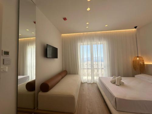 1 dormitorio con 2 camas y ventana grande en Villa Mucho, en Sarandë