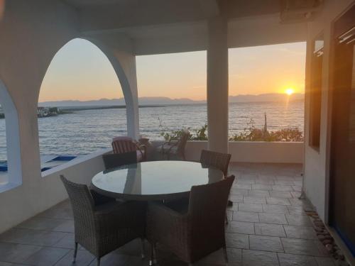 a table and chairs on a patio with a view of the ocean at Sunset Holiday House in Archangelos
