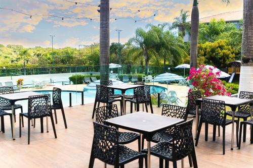 patio ze stołami i krzesłami przy basenie w obiekcie Hotel Dan Inn Franca & Convenções w mieście Franca