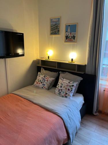- une chambre avec un lit et deux lampes murales dans l'établissement Studio Cosy en cœur de ville, à Pau