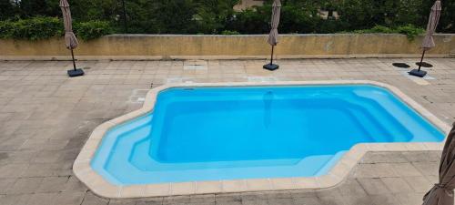 une piscine bleue entourée de parasols dans l'établissement Les naïades C7, jusqu'à 6 personnes, à Avène