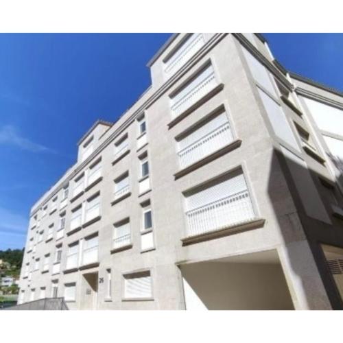 a large white building with a lot of windows at Aliving Colo in Raxo