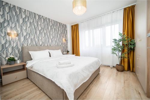 Un dormitorio con una cama grande y una ventana grande. en Feel the Paris with C&A apartment - By OpenHouse, en Timisoara