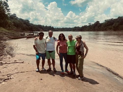 a group of people standing on a beach near the water at Sunrise of Tambopata in Puerto Maldonado