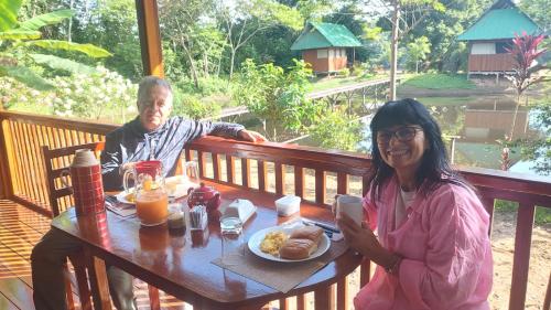 a man and a woman sitting at a table with a plate of food at Sunrise of Tambopata in Puerto Maldonado