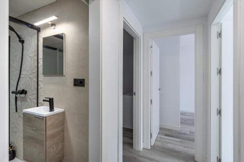 ein Bad mit einer Dusche, einem Waschbecken und einem Spiegel in der Unterkunft Apartamento moderno a 10 minutos del centro in Ogíjares