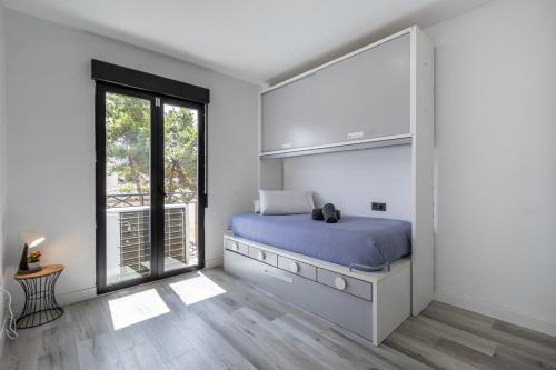 ein Schlafzimmer mit einem Bett und einem großen Fenster in der Unterkunft Apartamento moderno a 10 minutos del centro in Ogíjares