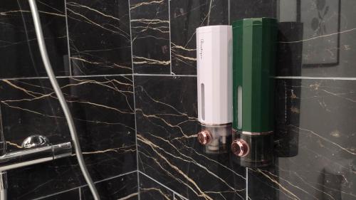 a green and white hair dryer on a wall at Cœur de Fontainebleau: Confort, Calme & Haut débit in Fontainebleau