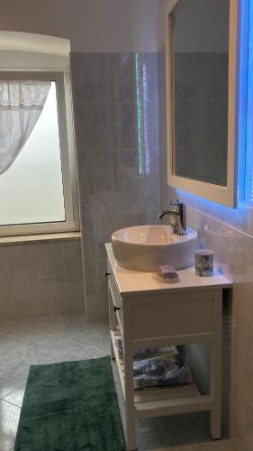 a bathroom with a sink and a window at Maggie ‘s home in Castellana Grotte