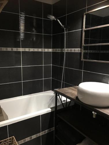 une salle de bain avec un lavabo et une baignoire dans l'établissement Sète Plage Corniche, à Sète