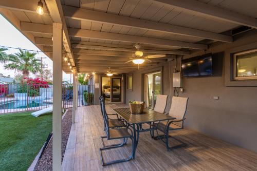 a patio with a table and chairs on a deck at Hot Tub, Heated Pool, Mini Golf, BBQ, 500 Mbps, 50in TV, Old Town in Scottsdale