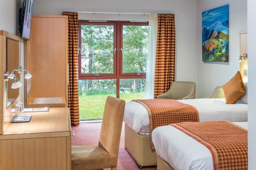 a hotel room with two beds and a window at High Range Lodge Hotel in Aviemore