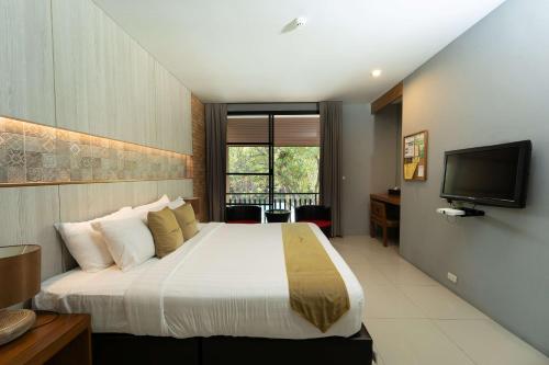 a hotel room with a bed and a television at Sukhothai Treasure Resort & Spa- SHA Plus Certified in Sukhothai