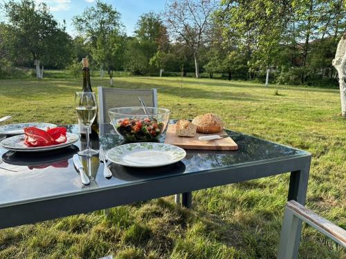- une table avec une assiette de nourriture et une bouteille de vin dans l'établissement Domaine La Bonne Dame - Merle, au coeur des Vosges, à Plainfaing