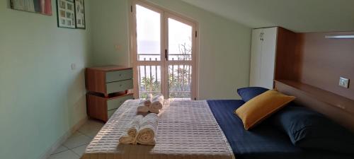 - une chambre avec un lit doté de tongs dans l'établissement Attico Marecielo Meraviglioso appartamento con terrazza panoramica vista mare, à Longobardi