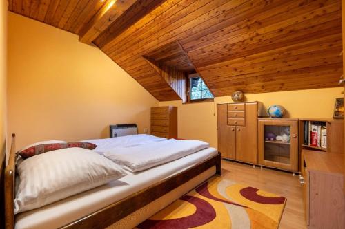 - une chambre avec un lit et un plafond en bois dans l'établissement VILA LIMACO JASENSKÁ DOLINA PRI MARTINE, à Horné Jaseno