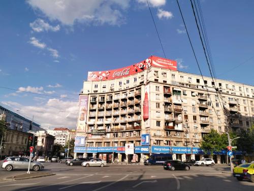 ein großes weißes Gebäude mit einem Coca-Cola-Schild darauf in der Unterkunft Panorama view with terrace in Bukarest