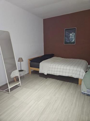 une petite chambre avec un lit et une chaise dans l'établissement Logement avec jardin gare St Charles, à Marseille
