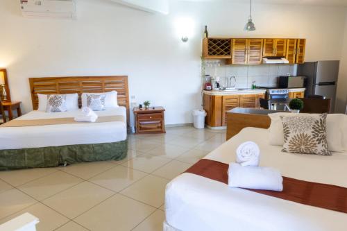 a hotel room with two beds and a kitchen at Hotel Scarlette in Tulum