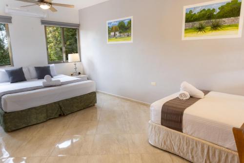 a bedroom with two beds and a couch at Hotel Scarlette in Tulum