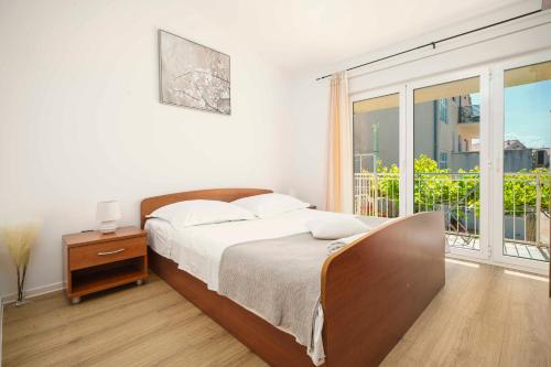 ein Schlafzimmer mit einem Bett und einem großen Fenster in der Unterkunft Apartments Vitis in Vodice