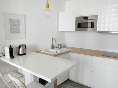 une cuisine blanche avec un évier et un comptoir dans l'établissement Escale 1 - Part Dieu, à Lyon