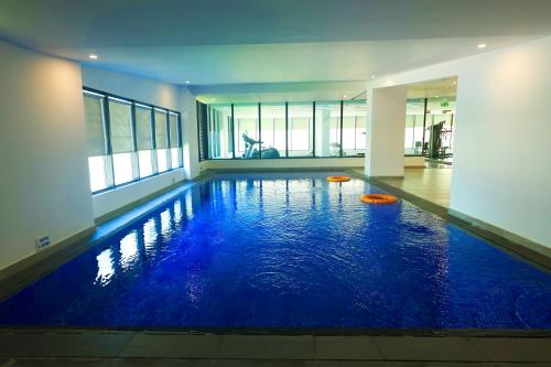 - une piscine d'eau bleue dans un bâtiment dans l'établissement Noor Amwaj Hotel & Apartment, à Manama