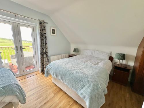 ein Schlafzimmer mit einem Bett und einem großen Fenster in der Unterkunft Whitestrand B&B in Malin Head