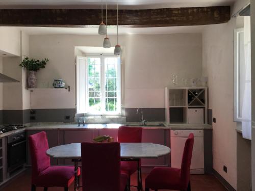 uma cozinha com uma mesa e cadeiras, uma mesa e uma janela em Villa Tambellini de Fondra em Lucca