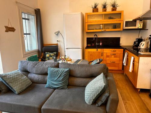 un salon avec un canapé et une cuisine dans l'établissement Loft Bleu, proche plage Bandol, à Sanary-sur-Mer