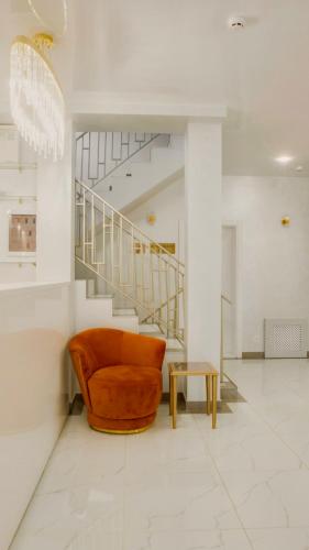 an orange chair in a room with a staircase at Salut in Bukovel