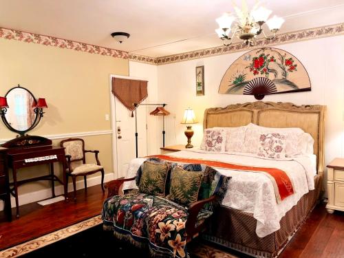 a bedroom with a bed and a chair and a table at Apple & Cherry Suite-heart of oldtown in Niagara on the Lake