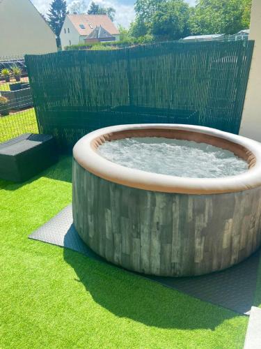 a large wooden tub sitting in the grass at Cocon à la campagne in Chilleurs-aux-Bois