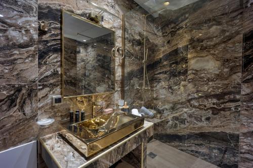 y baño con lavabo y espejo. en Royal Gold City Suites by Estia, en Heraclión