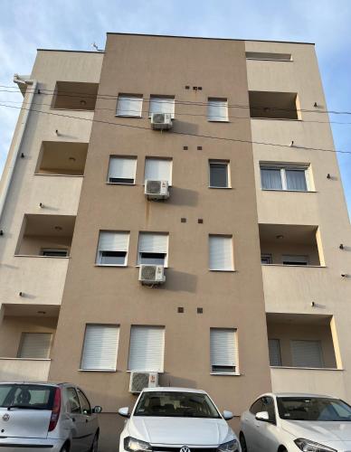 two cars parked in front of a tall building at Residence 25V in Batajnica