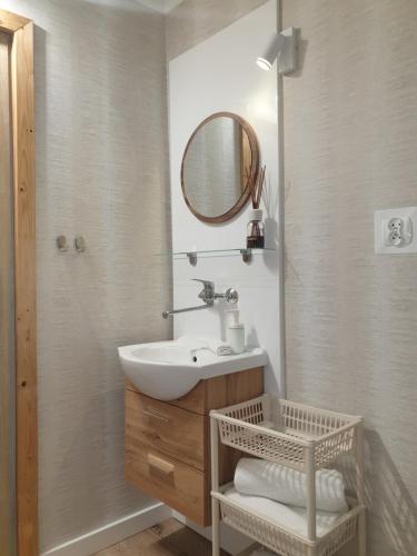 ein Bad mit einem Waschbecken und einem Spiegel in der Unterkunft Pokoje Sandra II in Łeba