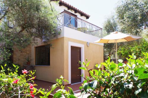 a house with an umbrella and some bushes at Elea in Kato Daratso
