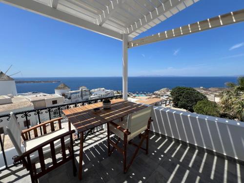 una mesa y sillas en un balcón con vistas al océano en Sunset view apartment, en Oia