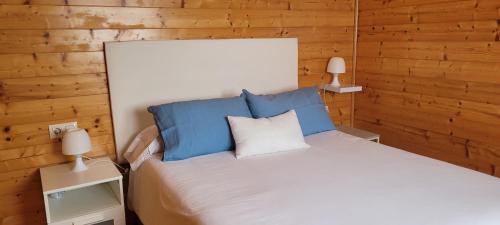 a bedroom with a bed with blue and white pillows at Apartadiño in Pobra do Caramiñal