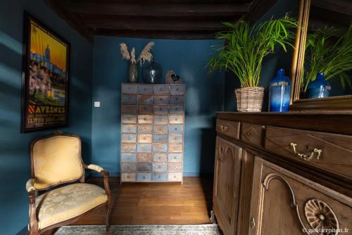 une pièce bleue avec une chaise et une commode en bois dans l'établissement La Marbaisienne, à Marbaix