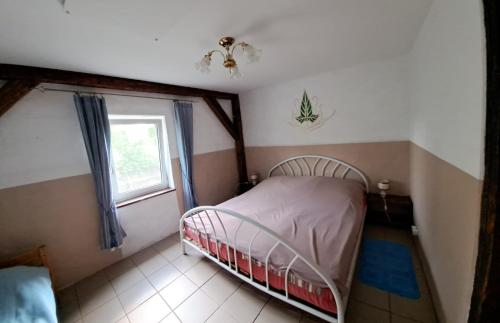 a small bedroom with a bed and a window at Śródziemie Lorien in Leśno