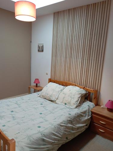 a bedroom with a bed with a wooden headboard at Marronnier 1 in Brioux-sur-Boutonne