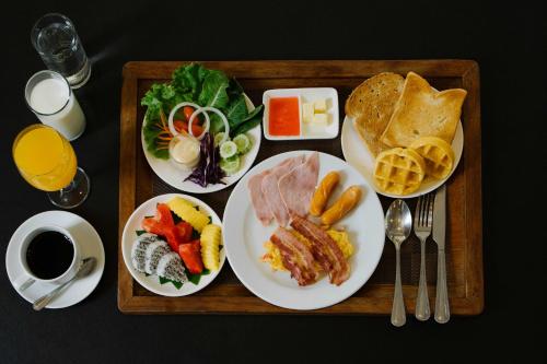 een dienblad met borden eten op een tafel bij Sukhothai Treasure Resort & Spa in Sukhothai