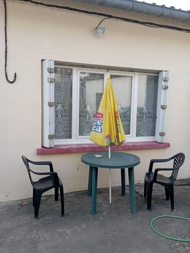 a table with a yellow umbrella and two chairs at Marronnier 1 in Brioux-sur-Boutonne