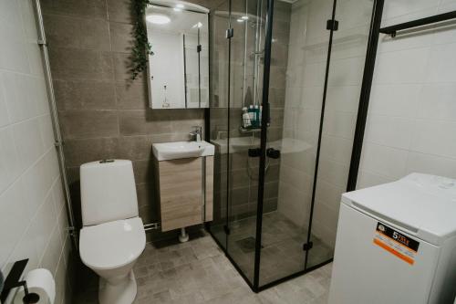 La salle de bains est pourvue d'une douche, de toilettes et d'un lavabo. dans l'établissement ~ A modern flat at a calm ground floor ~, à Espoo