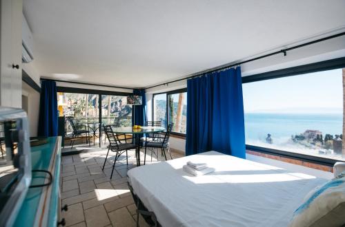 sypialnia z łóżkiem i widokiem na ocean w obiekcie BayView Apartment - Taormina Holidays w Taominie