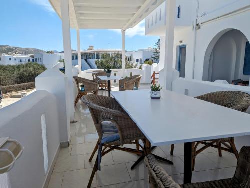 una mesa blanca y sillas en el balcón de una casa en Barbaras, en Naousa